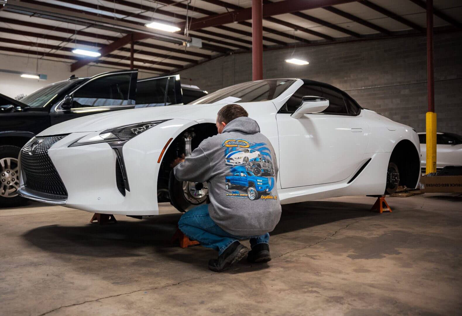 A man working on the tire of his car.