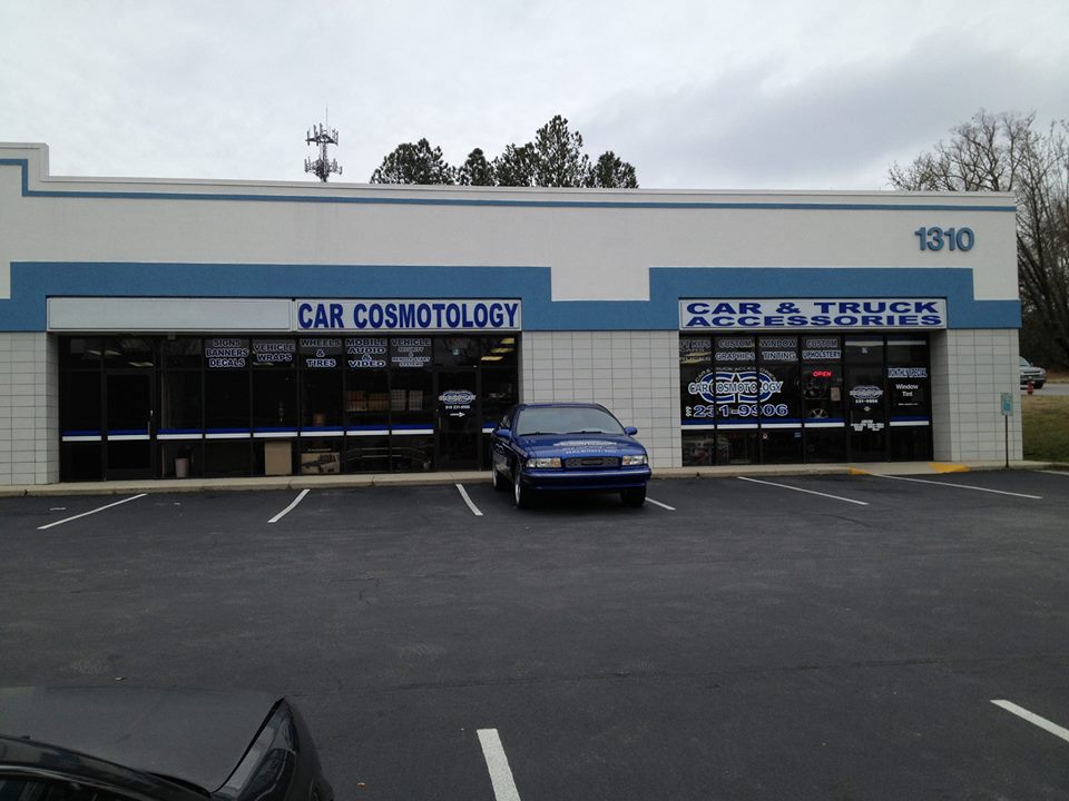 A blue car parked in front of a building.